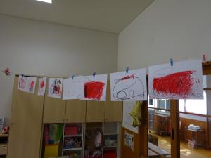 ３歳児の描いた個性的な消防車の絵が部屋に吊り下げられている。