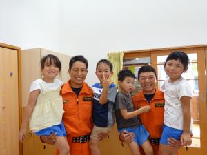 消防士さんに抱き上げてもらって、笑顔の５歳児。