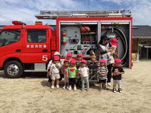 １歳児消防車をの前で