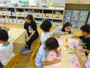 4歳児製作の様子を見ている高校生