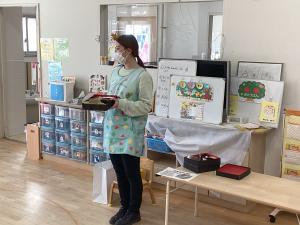 紙で作ったお節のお重をみせてくれる山根先生。