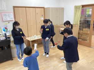 けんだまをする園児と小学生