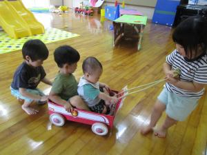 車のおもちゃで遊ぶ2歳児と0歳児